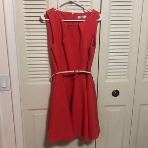 Sleeveless, coral colored, knee length dress.
